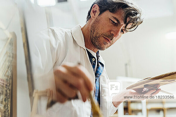 Craftsman wearing lab coat working in workshop
