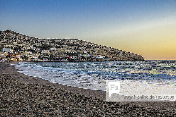 Greece  Crete  Matala  Matala Beach at dusk with village in background