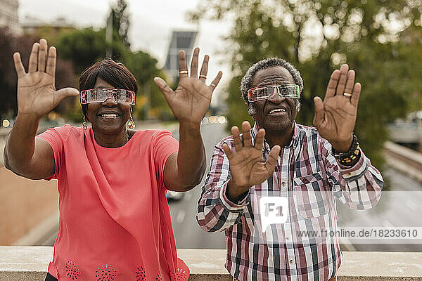 Senior couple showing palms wearing smart glasses