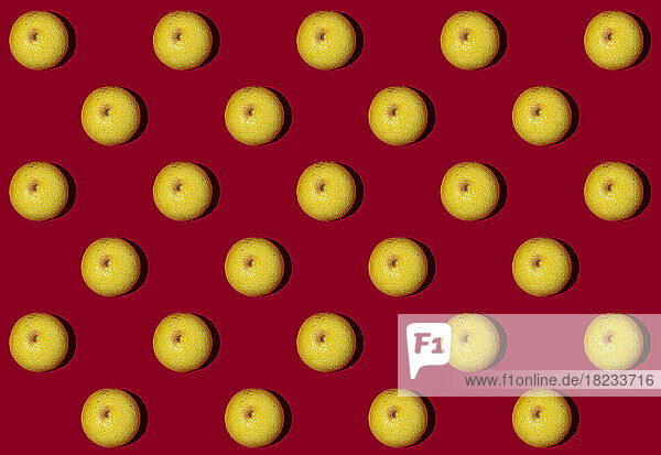 Pattern of halved lemons flat laid against red background