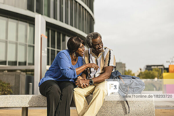 Man and woman talking to each other sitting on bench