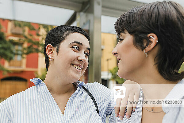 Lächelnde Frau mit der Hand auf der Schulter ihrer lesbischen Freundin