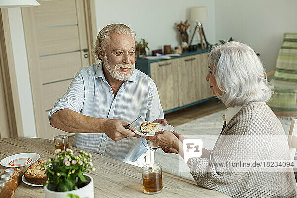 Senior couple having cake and tea at home