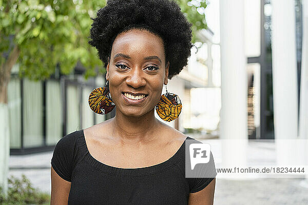 Happy woman with Afro hairstyle wearing earrings