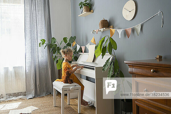Mädchen lernt zu Hause Klavier spielen