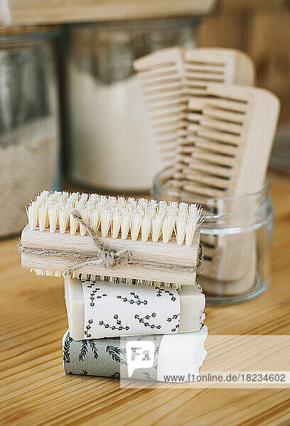 Stack of soap bars and scrubbing brush on table in shop