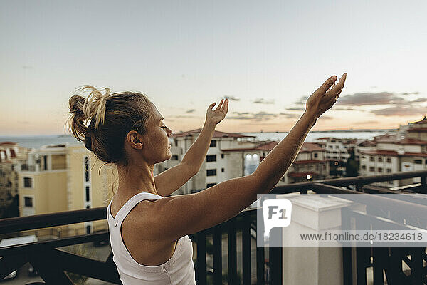 Serene woman enjoying the sunset on roof terrace
