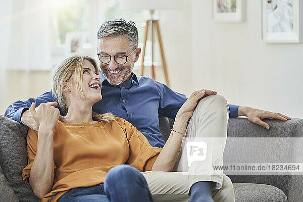 Happy couple on sofa in living room at home