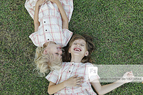Happy girl with sister enjoying on grass