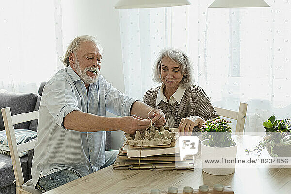 Senior couple bunching waste paper at home