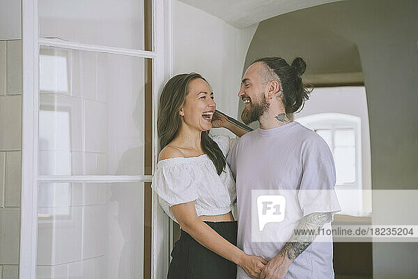Happy hipster man with girlfriend at doorway