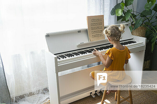 Girl practicing piano at home