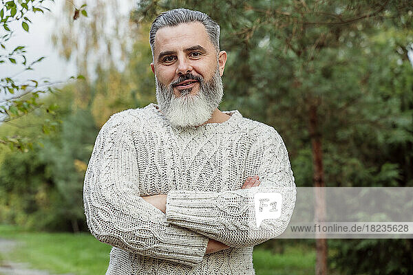 Mature man wearing sweater standing with arms crossed