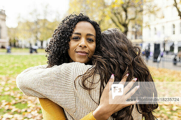 Frau umarmt Freundin im Park