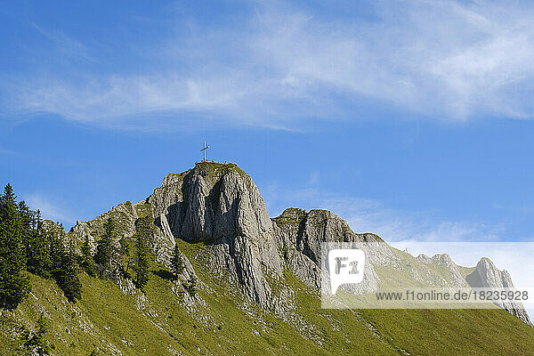 Gipfelkreuz auf dem Tegelberg unter blauem Himmel
