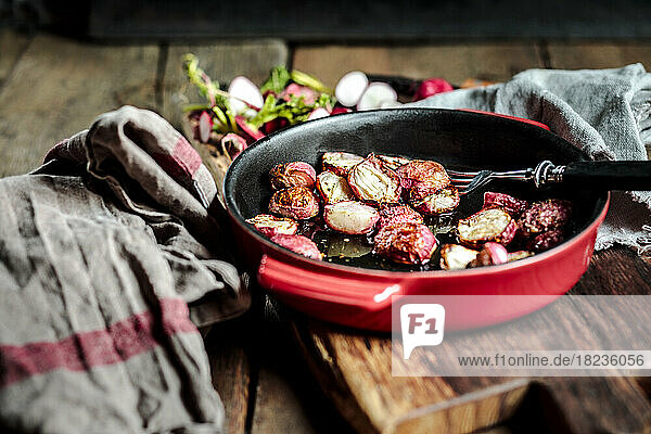 Baked radishes in casserole dish at table