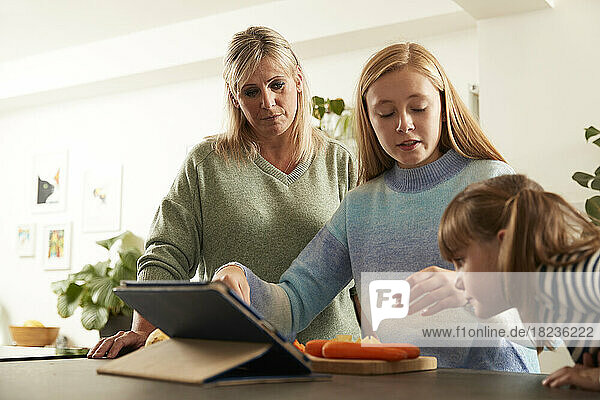 Mother with daughters at kitchen counter