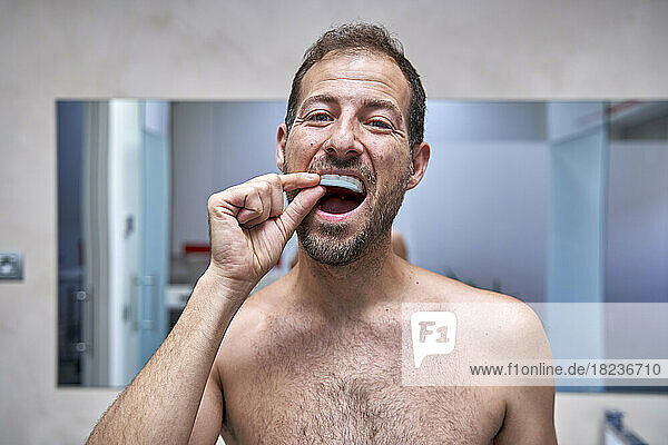 Man taking dental care in bathroom at home