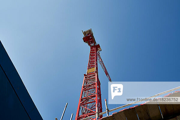 Red crane machinery under blue sky