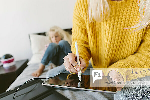 Woman using tablet PC with digitized pen at home
