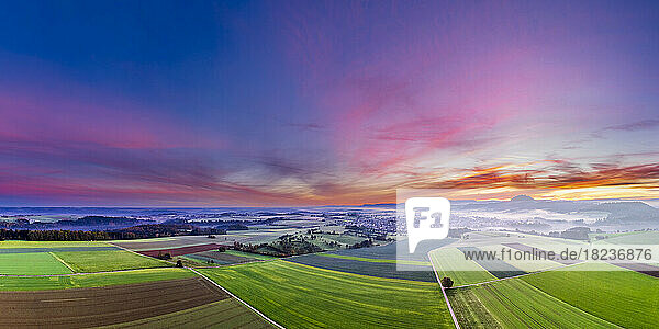Germany  Baden-Wurttemberg  Drone view of purple clouds over countryside fields at dawn