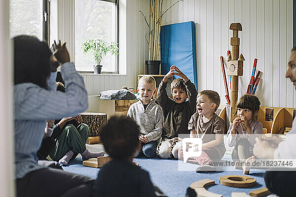 Kinderbetreuerin unterrichtet Jungen und Mädchen in einer Kindertagesstätte