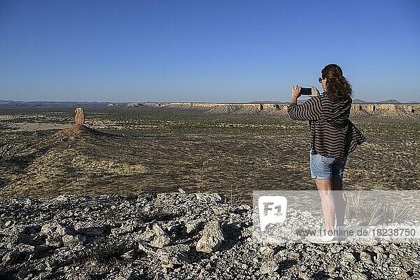 Touristin fotografiert die Fingerklippe  Vingerklip  Felsnadel im Ugab-Tal  Region Kunene  Namibia  Afrika
