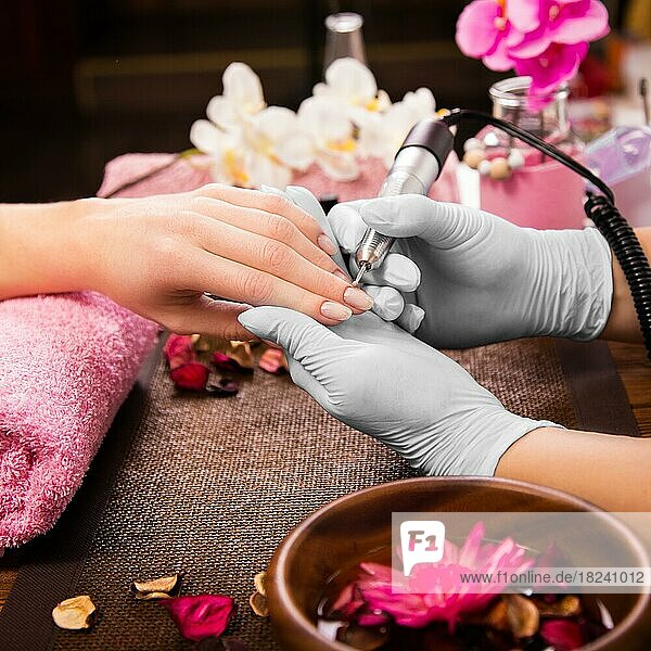 Closeup Fingernagelpflege durch Maniküre Spezialist in Schönheitssalon. Maniküre klar Nagelhaut professionelle Elektrowerkzeug für Maniküre und Pediküre