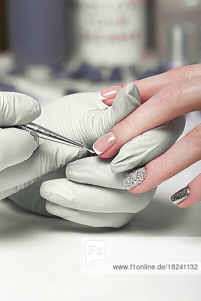 Closeup Fingernagelpflege durch Maniküre Spezialist in Schönheitssalon. Maniküre malt Nägel mit Nagellack