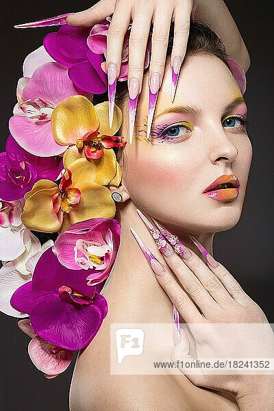 Schöne Frau mit langen Nägeln  perfekter Haut  Haaren aus Orchideen. Porträtaufnahme im Studio