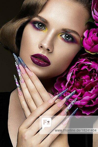 Schönes Mädchen mit buntem Make-up  Blumen  Retro-Frisur und langen Nägeln. Maniküre Design. Die Schönheit des Gesichts. Fotos im Studio aufgenommen
