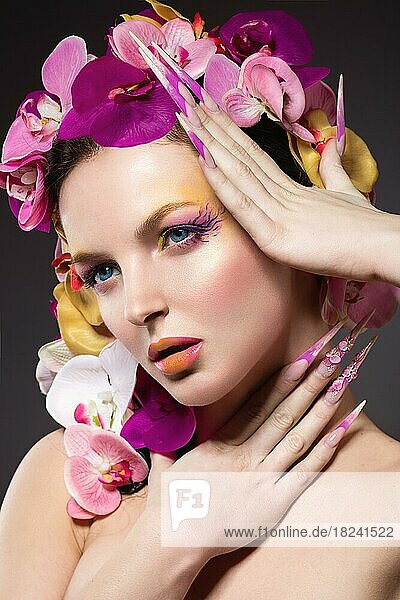 Schöne Frau mit langen Nägeln  perfekter Haut  Haaren aus Orchideen. Porträtaufnahme im Studio