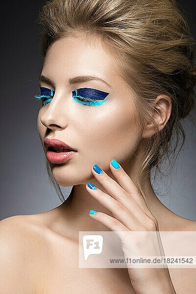 Schönes Mädchen mit hellen kreativen Mode Make-up und blauen Nagellack. Kunst Schönheit Nageldesign. Bild im Studio aufgenommen