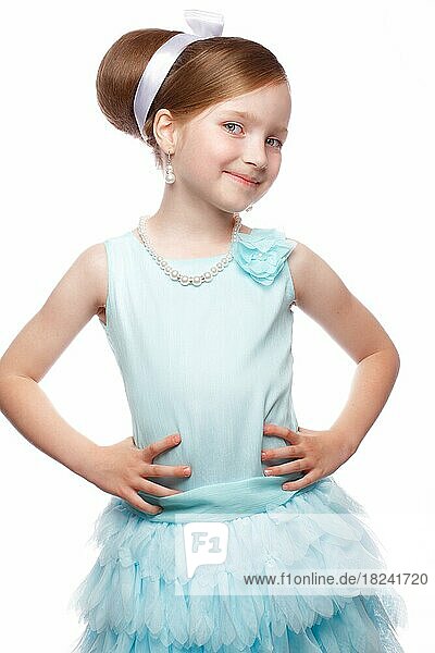 A little girl in a blue dress  with a retro hairstyle and accessories. Photo taken in studio