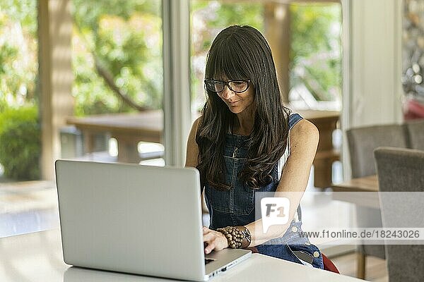 Business woman working from home while looking at laptop