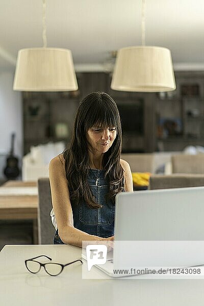 Geschäftsfrau arbeitet von zu Hause aus mit ihrem Laptop