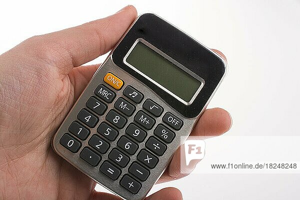 Hand holding a calculator on a white background