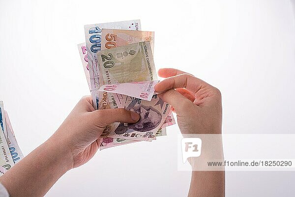 Hand hält türkische Lira-Banknoten auf weißem Hintergrund
