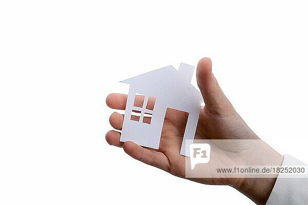 Hand hält ein isoliertes Papierhaus mit weißem Hintergrund