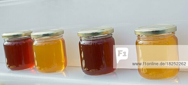 Glasgefäß mit frischem Honig und Deckel