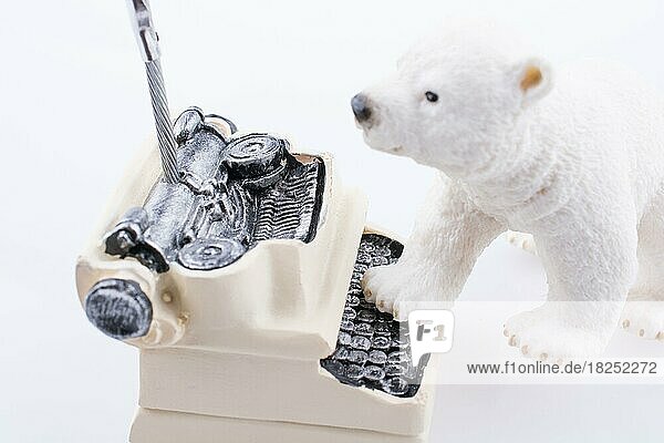 Polar bear cub on the roof of a model house mado of roof