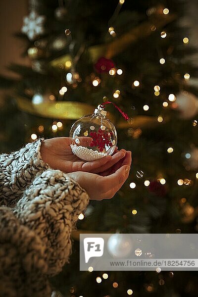 Frau hält kleine Christbaumkugel in der Hand. Auflösung und hohe Qualität schönes Foto