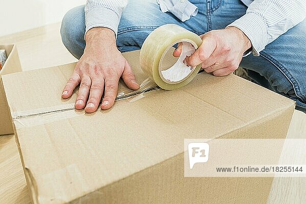 Junger Mann Abdichtung Karton mit Klebeband groß bewegen. Auflösung und hohe Qualität schönes Foto