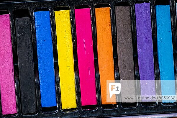 Buntstifte in verschiedenen Farben in einer Schachtel auf einer Leinwand