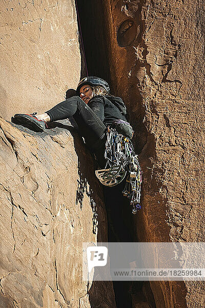 Woman climbing rock formation at Bride Canyon