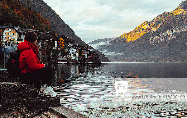 woman sitting and looking at the panorama by the lake