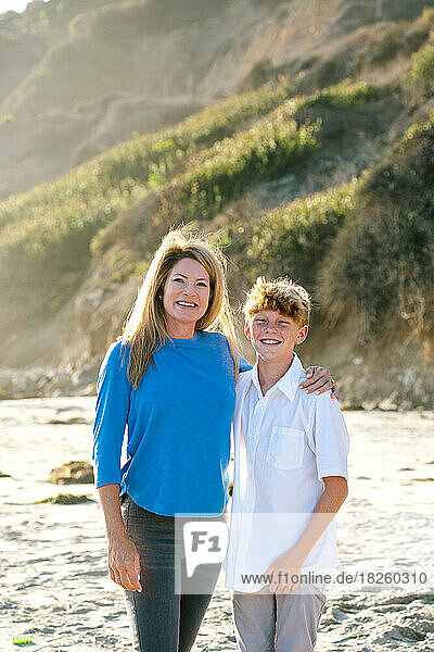 Mother And Tween Son Smile For A Portrait At The Beach
