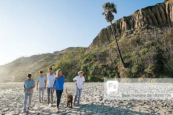 Family Of Five Walk On The Beach In Malibu