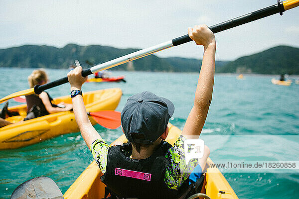 Excited boy in kayak on ocean adventure with family and group
