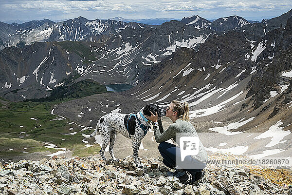 Side view of woman kissing dog while hiking at Electric Pass in winter